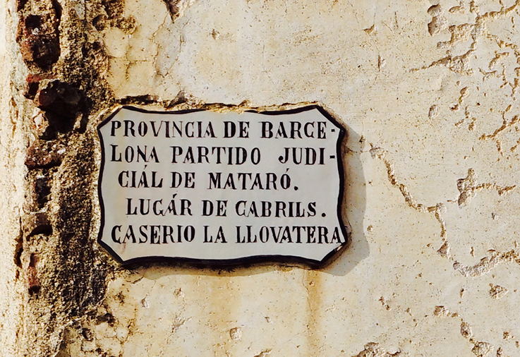 Antiga placa amb la indicació del veïnat de La Llobatera. Itinerari per Cabrils
