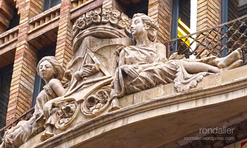 Conjunt escultòric amb l'escut i una noia asseguda a cada costat. Cooperativa La Fraternitat de la Barceloneta