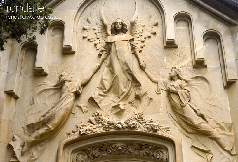 Relleu d'un àngel amb dues ànimes al panteó Via Oliveras, projectat per Santiago Güell.